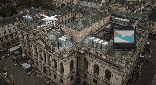 Quadcopter drone with sensor fusion data overlay surveying a historic buildings roof.