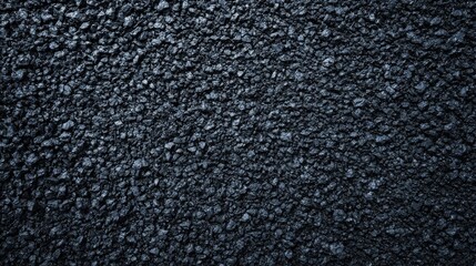 Fototapeta premium Close-up of a textured, dark asphalt surface with a rough appearance.
