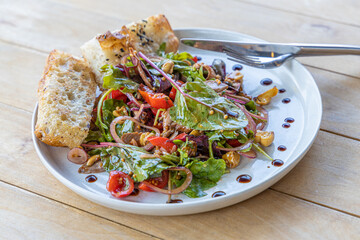 meat salad, bacon, egg, crouton, lettuce, salad dressing vinaigrette  saladcopy space food background rustic top view