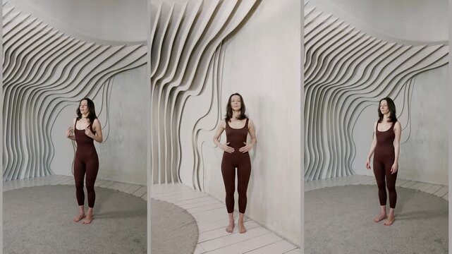 a neutral pose in the process of learning to pose, hands along the body, a light wall with relief lines on the background.