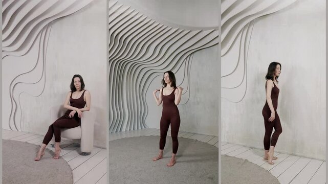 A woman in a brown jumpsuit stands against a wall in the process of learning to pose, her hand on her face, her legs apart.