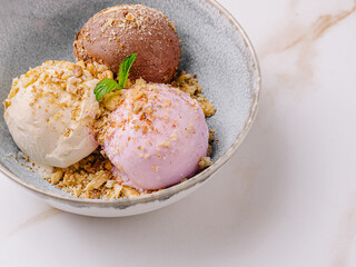 Different flavors of ice cream served in a bowl with toppings