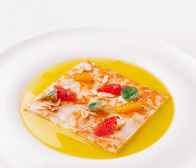 Delicious dessert with fruit, nuts, and syrup served on a white plate