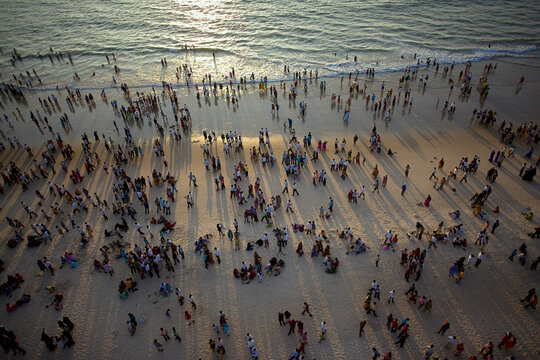 Mangaluru, India - 17 January 2010: Aerial view of Panambur Beach, where the golden sand meets the foamy waves, as people enjoy the warm sunlight.