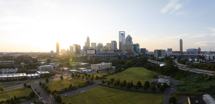 Charlotte, United States - 30 July 2025: Aerial view of a skyline punctuated by the iconic Bank of America Corporate Center and the lush green spaces below.