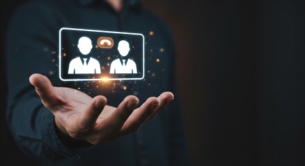 A person's hand holding a digital screen displaying a video conference call between two people, with a dark background.