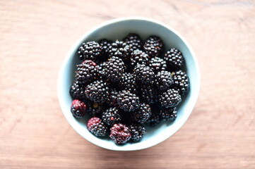 Top view of a bowl filled with fresh blackberries. The vibrant dark purple berries create a visually appealing and healthy snack option, perfect for summer, natural food, and fruit themes.