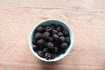 Top view of a bowl filled with fresh blackberries. The vibrant dark purple berries create a visually appealing and healthy snack option, perfect for summer, natural food, and fruit themes.