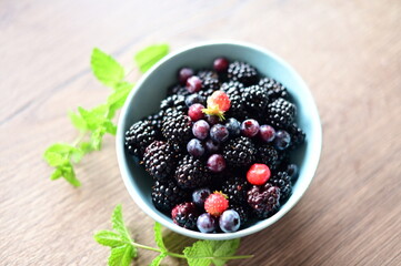 Top view of a bowl filled with fresh blackberries. The vibrant dark purple berries create a visually appealing and healthy snack option, perfect for summer, natural food, and fruit themes.