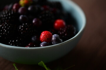 Close-up macro view of a bowl with fresh seasonal fruits — blackberries, blueberries, and mint. A vibrant and healthy mix of summer berries, perfect for fresh eating, healthy lifestyle, and food photo