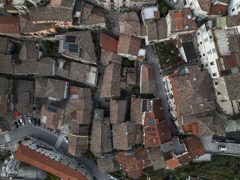 Aerial view of terracotta rooftops cascading down ancient streets, creating a textured tapestry of urban life, Morcone, Benevento, Campania, Italy.