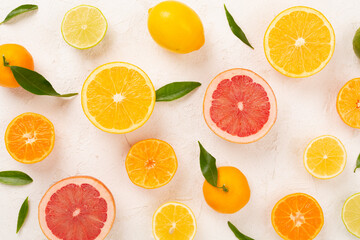 Different citrus fruits on concrete background, top view