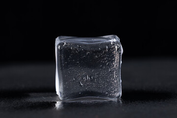 Clear ice cube set against a dark, possibly black, background.