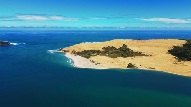 Aerial view of the stunning contrast between the deep blue sea and sandy dunes, a tranquil coastal landscape, Omapere, Northland Region, New Zealand.
