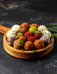 Assorted healthy energy balls in wooden bowl