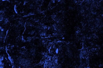 Close-up view of a blue textured wall showing rough patterns and intricate shadow details, offering a visually appealing background texture for versatile creative uses.