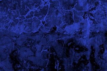 Close-up view of a blue textured wall showing rough patterns and intricate shadow details, offering a visually appealing background texture for versatile creative uses.