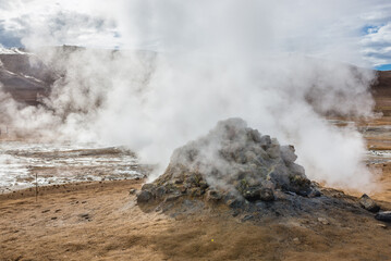 Steaming cone in Hverir geothermal area with boiling mudpools and steaming fumaroles in Iceland