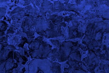 Close-up view of a blue textured wall showing rough patterns and intricate shadow details, offering a visually appealing background texture for versatile creative uses.