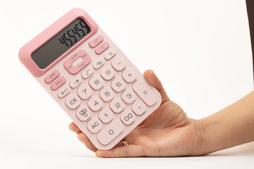 A person's hand holds a small, portable, pink calculator with a digital display showing 455459 against a clean white background