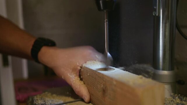 Close-up of a wooden plank being drilled on a machine in a carpentry workshop. The process of woodworking and precision drilling. High quality 4k footage
