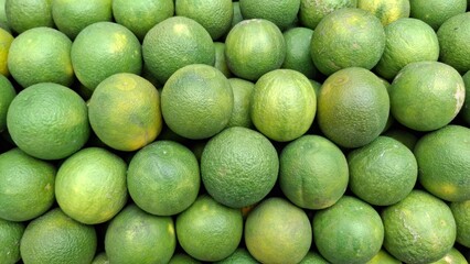 Abundant Harvest of Green Oranges – Fresh Citrus Display, Farm Produce, Vitamin C Source, Natural Food Background, Healthy Lifestyle, Market Fruit Stack
