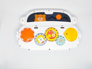 Obraz premium A white baby toy car featuring colorful gears, a smiling bear, and interactive elements, perfect for early childhood development and sensory exploration.