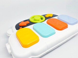 Close-up of a colorful toy car dashboard with buttons and a steering wheel isolated on a white background. Perfect for illustrating concepts related to play and childhood.
