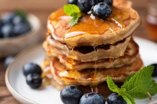 Pancakes with drizzling honey and blueberries, closeup view