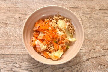 fried instant yellow noodles and cabbage with carrot topping shrimp egg on bowl