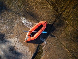Red packraft on the granite coast top view
