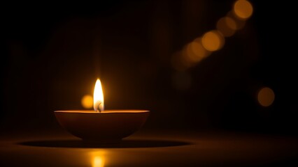 Golden diya glowing in darkness, symbolizing tradition and festive spirit in Indian culture.