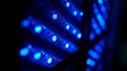 Close-up of glowing blue server rack lights creating an abstract technological pattern on a dark background.