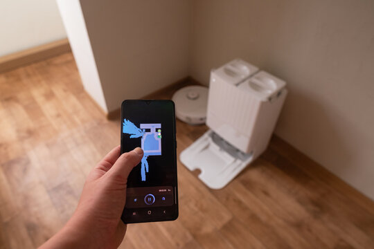 Smartphone screen displays app for controlling robot vacuum using modern technology for efficient home cleaning and convenience