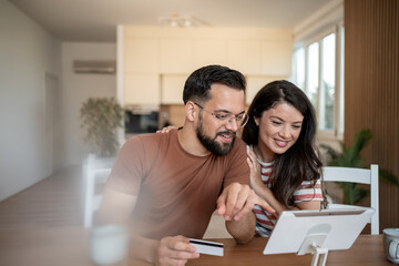 Couple doing online shopping using tablet and credit card at home