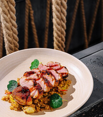 Sliced roasted duck served on flavorful fried rice with greens
