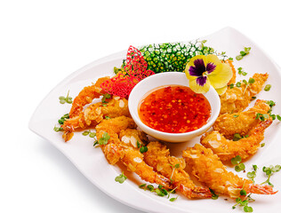 Crispy shrimp with dipping sauce and fresh vegetables arranged on a plate