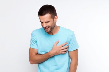Young man grimacing from sharp chest pain due to a heart problem