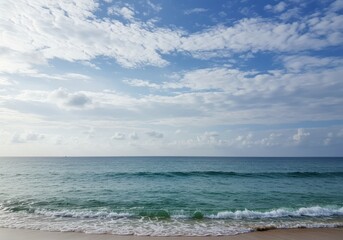 Fototapeta premium Vast ocean horizon under a dramatic sky with wispy clouds and gentle waves