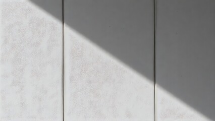 Textured concrete wall with neutral tones and subtle shadows from directional lighting.