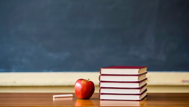 Chalkboard with apple and books on wooden school desk