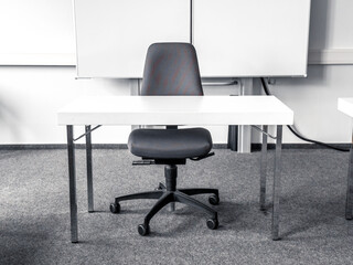 White table and gray chair in empty classroom