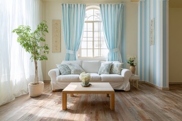 Light-filled, airy living room with white sofa, light wood floors, and blue striped curtains