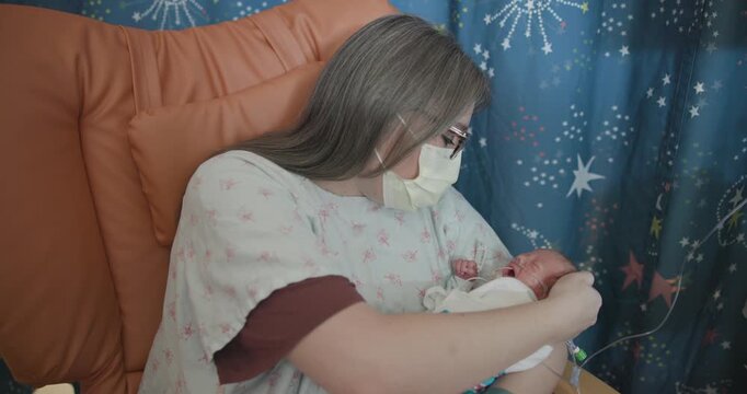 Mother Holding Newborn Preemie in the NICU