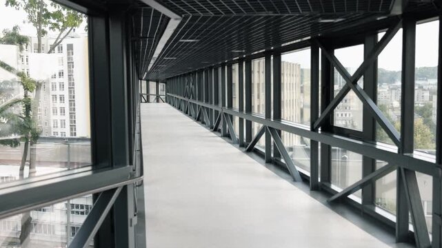 lockdown, structural design, glass connection. Up-to-date, glass-paneled skywalk with metallic supports, bridging two edifices, uninhabited, in period lockdown.