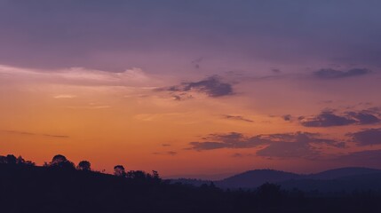 Obraz premium Vibrant Sunrise Over Mountain Range: A Colorful Dawn Landscape with Hues of Orange, Purple, and Silhouette