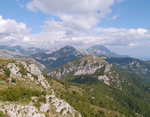Naklejka premium Mountain peaks and valleys under a partly cloudy sky