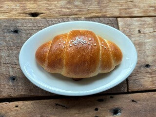 Golden brown salt bread with a soft, fluffy interior and a perfectly crisp crust, lightly sprinkled with coarse salt for a savory touch. A simple yet satisfying treat for any occasion.