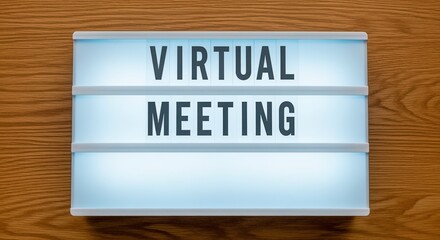 Fototapeta premium Virtual Meeting Lightbox Sign on Wood Background for Online Collaboration and Communication Concepts
