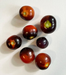 Seven tomatoes on a white background.